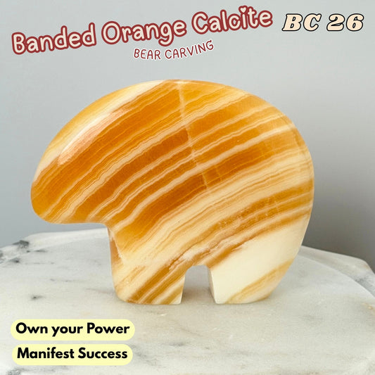 A carved bear-shaped stone sculpture with banded orange, amber, and cream calcite patterns, displayed on a light marble surface against a neutral gray background with promotional text overlays.