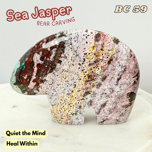 A polished Sea Jasper bear-shaped carving with a marbled pattern of pink, white, gold, and dark brown, displayed on a light marble surface with text overlays.
