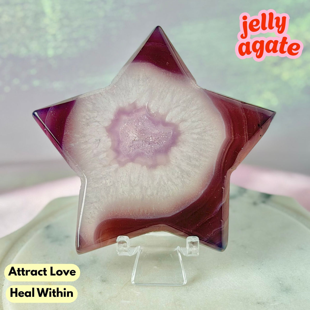 A star-shaped jelly agate crystal displayed on a clear acrylic stand. The crystal features a natural banded pattern with a deep purple outer ring, a white middle band, and a soft pinkish-purple core.